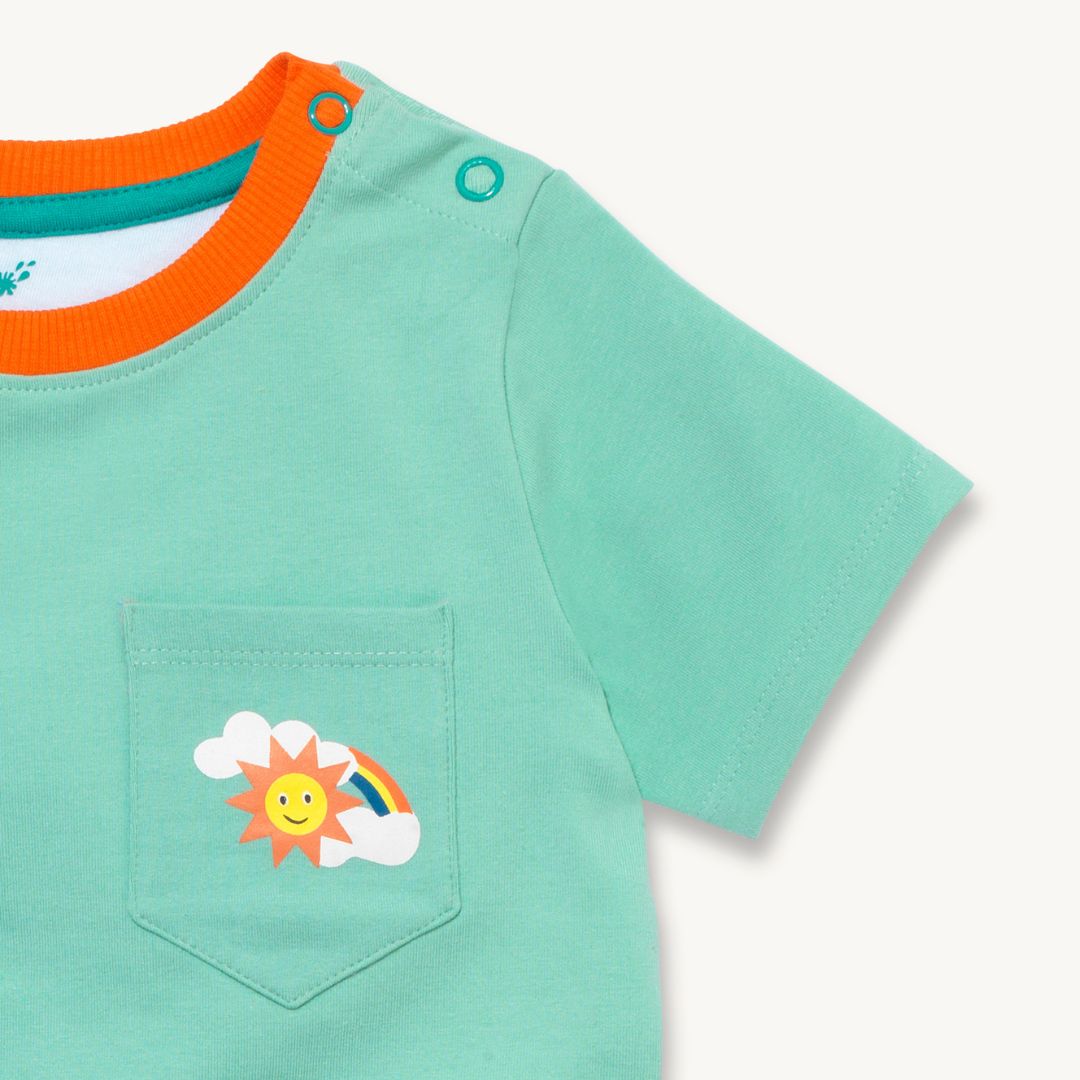 Close up image of a light green Ducky Zebra t-shirt with a contrasting orange trim on the neck. The t-shirt has a front pocket on the right hand side with a fun rainbow print.