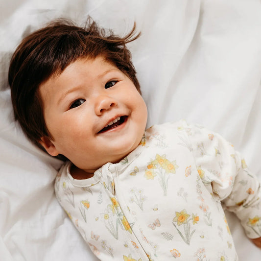 Baby smiling in soft organic cotton and bamboo babygrow - importance of natural non-toxic cosmetics for kids UK | Kiddykind
