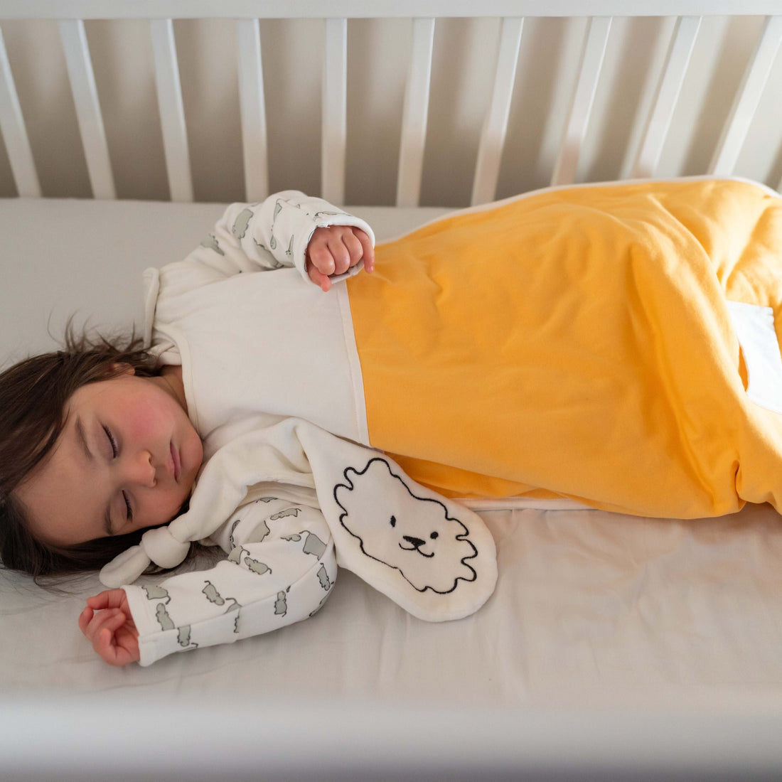 Baby sleeping contentedly in Pure Earth organic cotton sleeping bag - how natural fibres improve baby and toddler sleep UK | Kiddykind