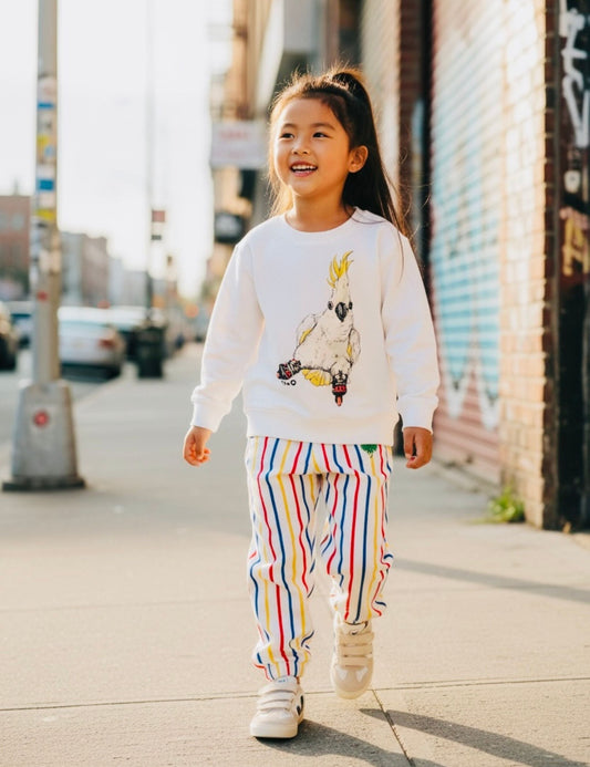 Child in organic cotton cockatoo print sweatshirt on a sunny street - sustainable baby and kids gift ideas for every budget UK | Kiddykind