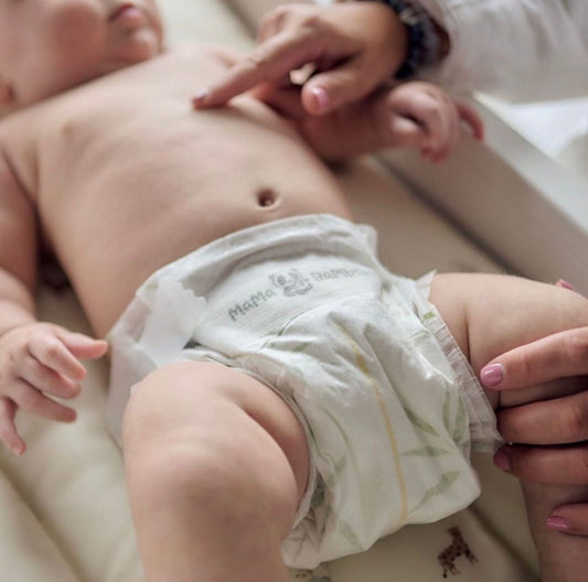 Parent giving gentle baby massage to newborn on soft mat - benefits of baby massage from newborn to toddler UK | Kiddykind