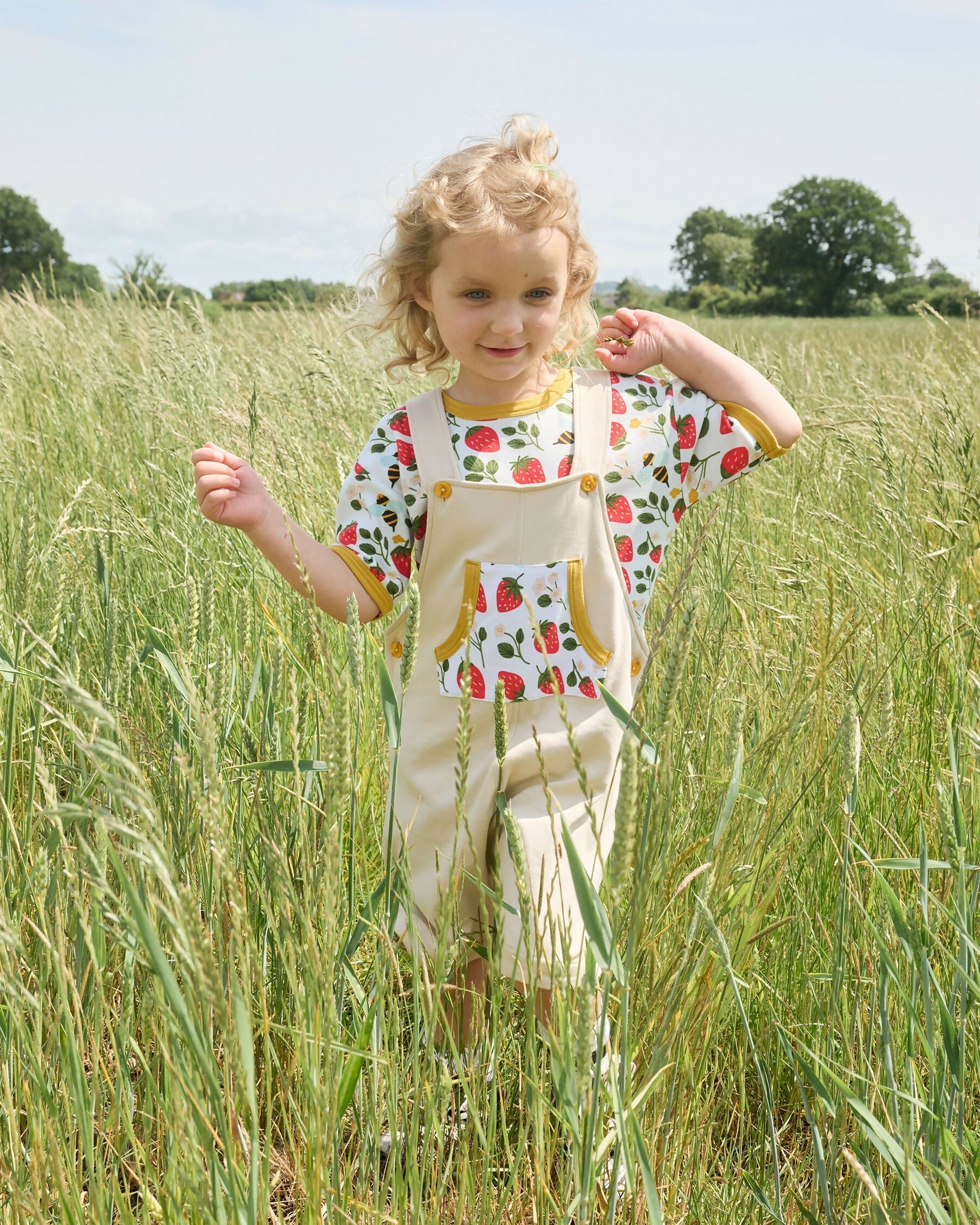 Girl playing in nature wearing organic cotton clothing for kids and organic cotton t-shirt for babies 