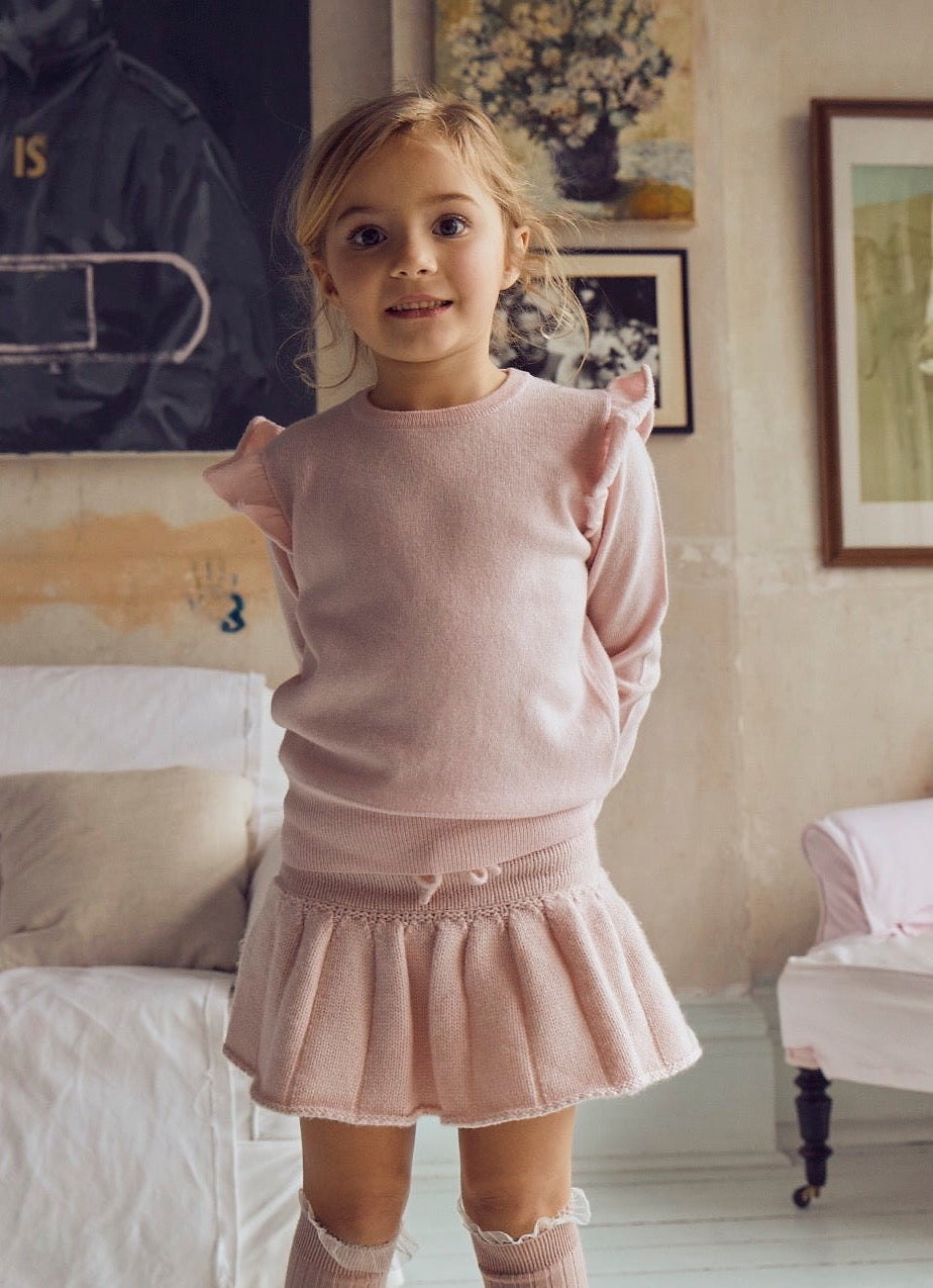 This timeless 2 ply Jumper in Blush Pink comes with a sweet little ruffle on the shoulder for a subtle elegant look. Made with a lovely cashmere/super soft merino blend from Inner Mongolia, it will keep your Little One stylish and warm all winter long.   Team it up with our matching pleated Tennis Skirt in Blush Pink for a head-to-toe snuggly feel. 