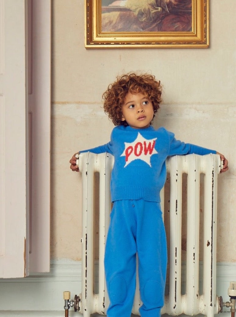 Bang, Crash, Thump: POW. This cosy 4 ply jumper comes with a double collar rib and POW emblazoned across the front super hero style. It will appeal to all young super heroes in the making.   Made with the softest cashmere/ merino blend from Inner Mongolia, it will keep you Little One cosy and warm all winter long.   Team it up with our matching Boy Pants in Bright Blue for a head-to-toe cosy feel. 