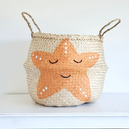 Handwoven seagrass storage basket with orange starfish design