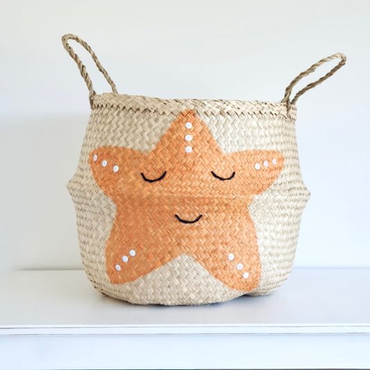 Handwoven seagrass storage basket with orange starfish design