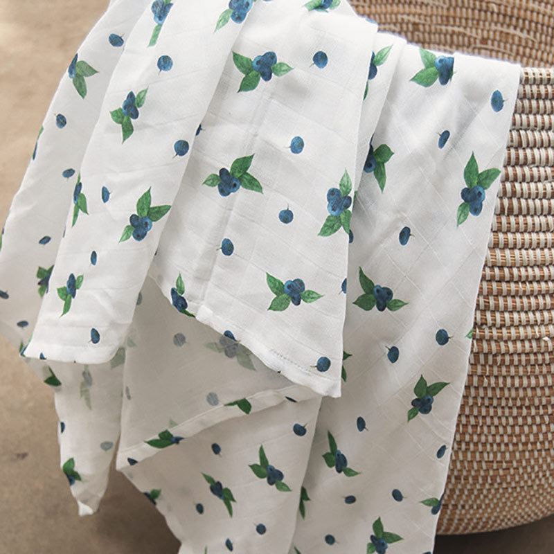 A soft organic muslin swaddle with a watercolour blueberry print Evie & Skye