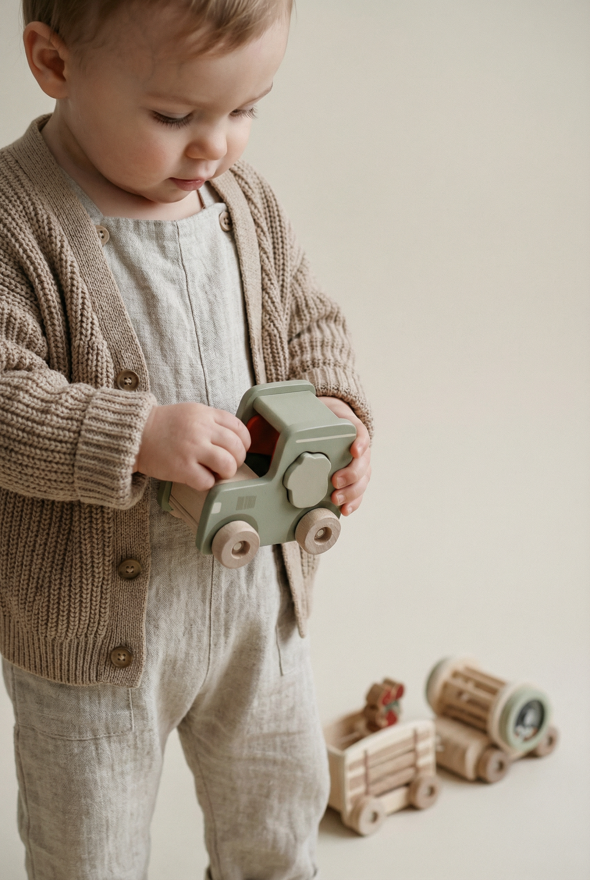 Neutral wooden tractor and trailer toy with rattle drum, view 2