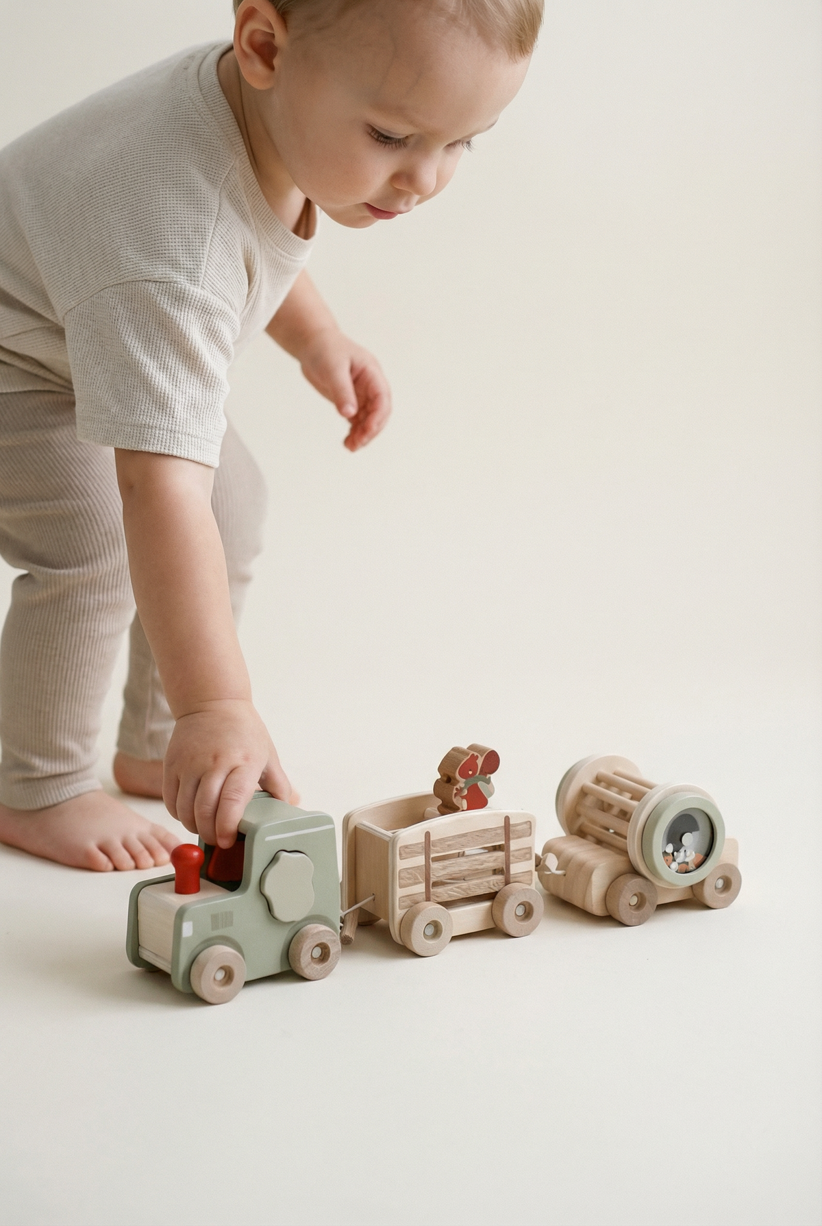 Neutral wooden tractor and trailer toy with rattle drum