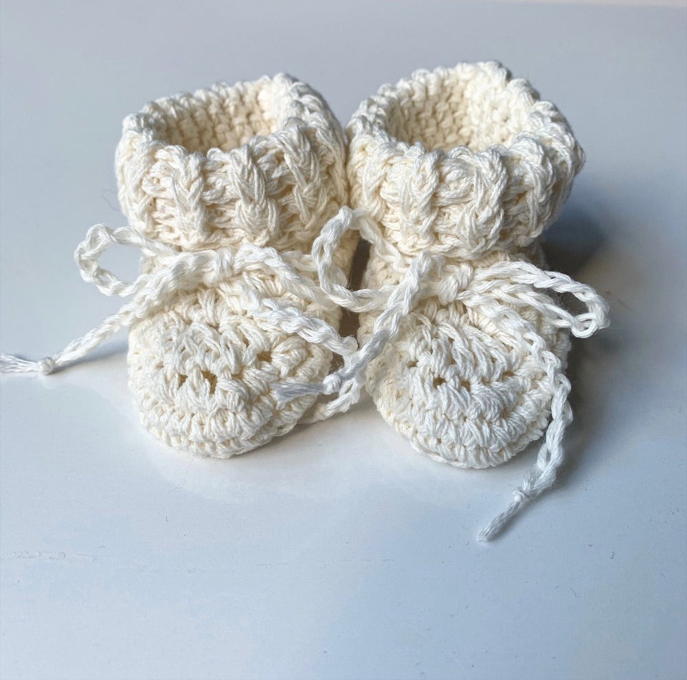 image shows a pair of cream organic cotton baby booties
