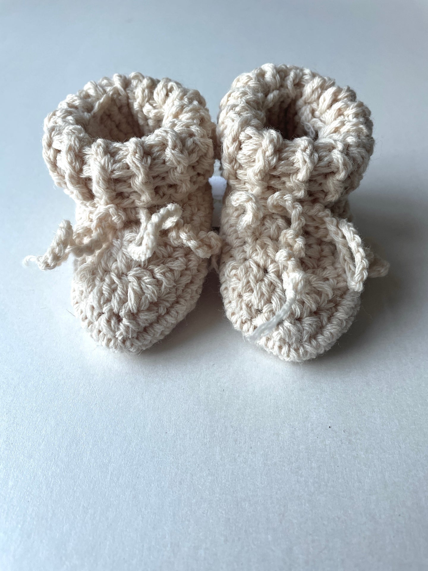 image shows organic wool creme baby booties