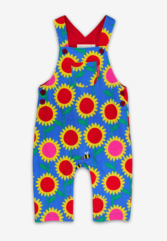 Colorful children's overalls with sunflower pattern on a white background