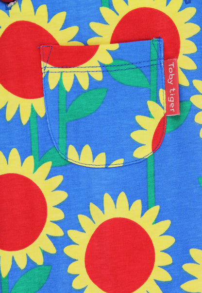 Close-up of a fabric with sunflower pattern and 'Toby Tiger' label on blue background