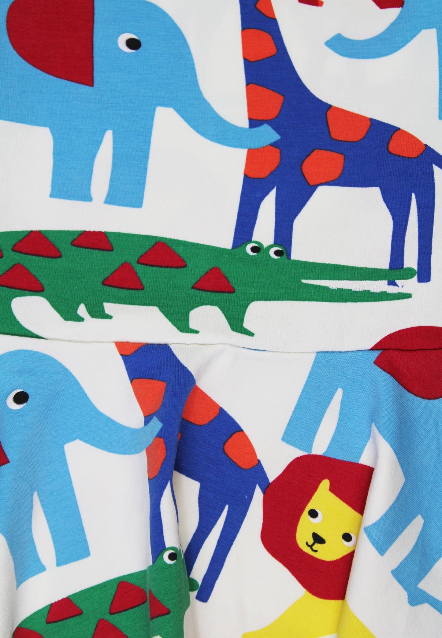 Colorful fabric with animal prints including elephants, giraffes, crocodiles, and a lion.