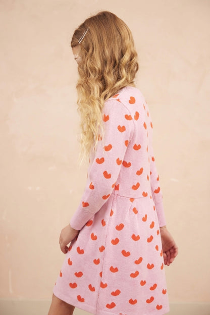 Side view of a girl in the Love Hearts Dress in bubble gum pink