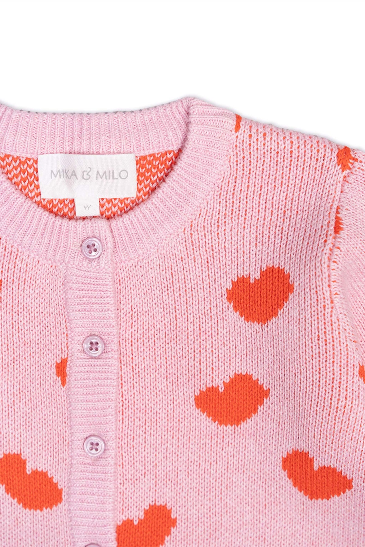 Close-up of the jacquard-knit hearts on the bubble gum pink peplum cardigan