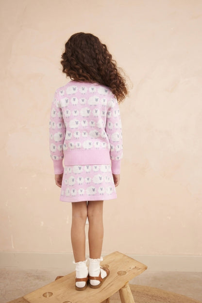 Side view of a girl in the Little Bo Peep jumper and skirt in bubble gum pink