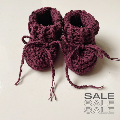 Image shows a pair of mulberry coloured organic cotton crocheted booties