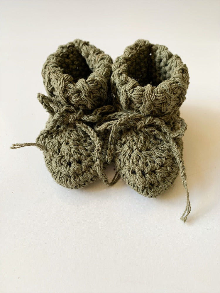Image shows a pair of olive green organic cotton tie booties.