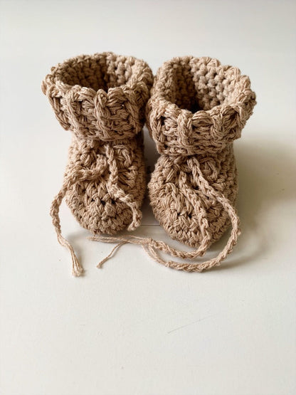Image shows a pair of beige, neutral organic cotton baby booties