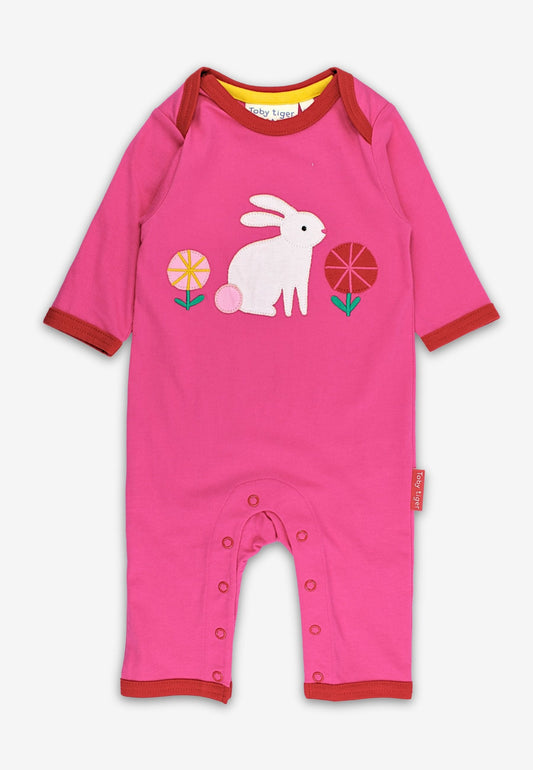 Pink baby romper with a white rabbit design on a white background