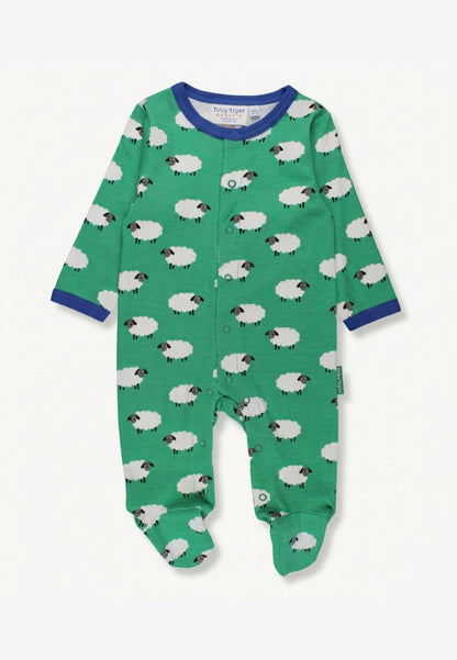 A baby long-sleeve footed sleeper in green with a white sheep pattern, featuring blue trim at the collar and cuffs, shown flat on a white background.