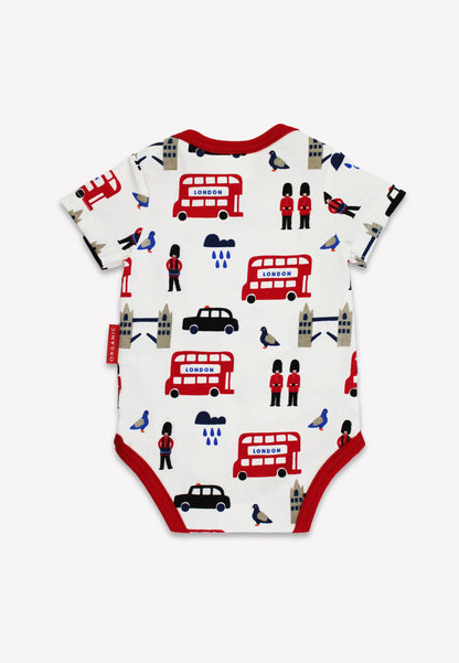 Baby onesie with London-themed print featuring red buses, black cars, and British flags on a white background.