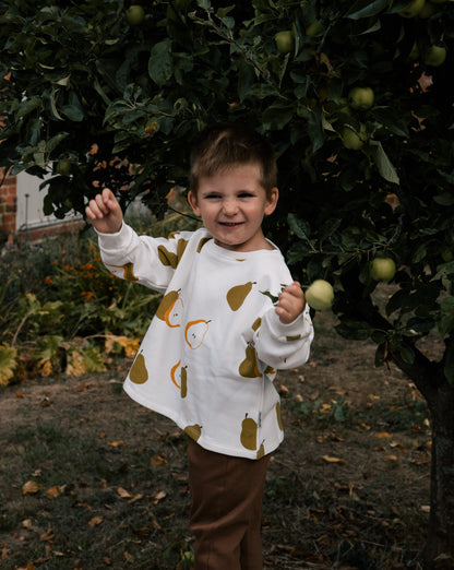 Toddler wearing Wildgreen Autumn Pear print sweater made from organic undyed cotton, unisex and gender-neutral sustainable kidswear, whilst apple picking