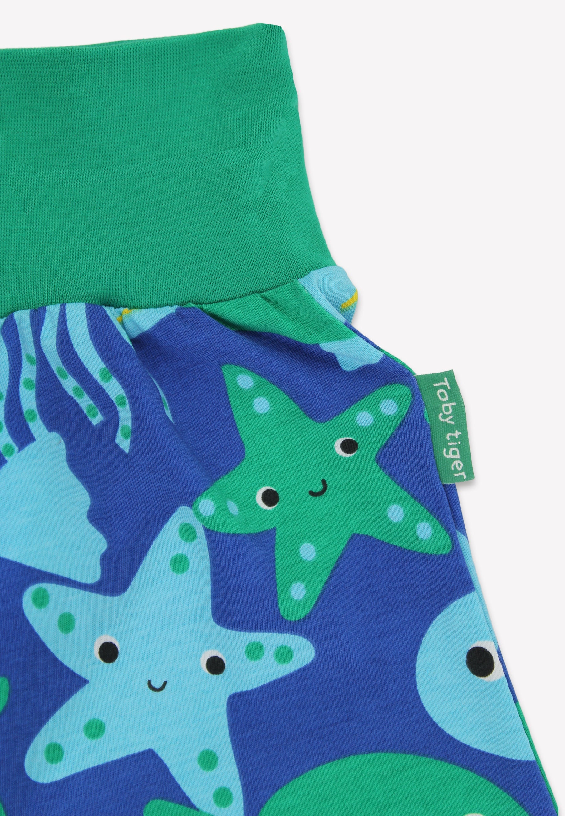 Children's pants with starfish pattern and green waistband on a white background