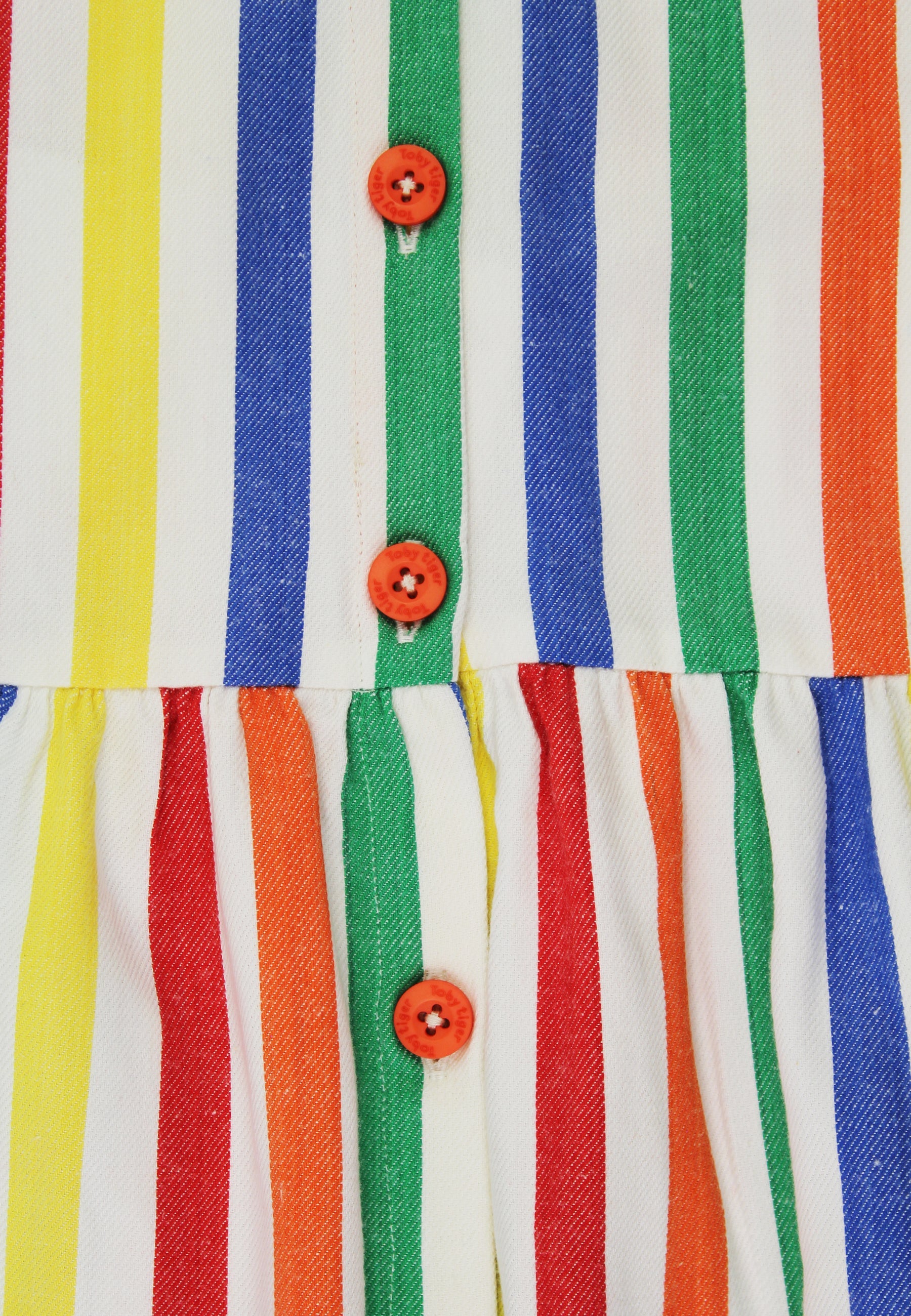 Close-up of a colorful striped fabric with orange buttons.